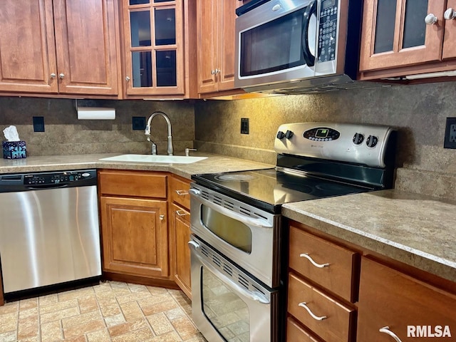 3205 Ashley Ln, Springfield, IL 62711 - kitchen with appliances with stainless steel finishes, decorative backsplash, brown cabinetry, and light countertops