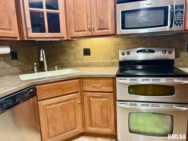 3205 Ashley Ln, Springfield, IL 62711 - kitchen with appliances with stainless steel finishes, light countertops, tasteful backsplash, and glass insert cabinets