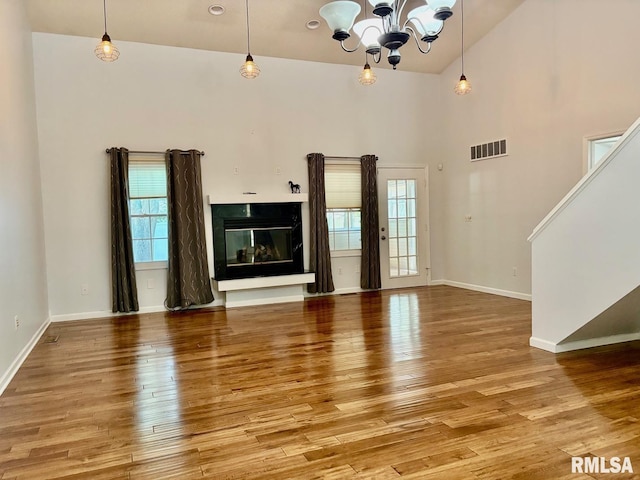 3205 Ashley Ln, Springfield, IL 62711 - unfurnished living room with light wood-type flooring, a chandelier, a premium fireplace, and stairway