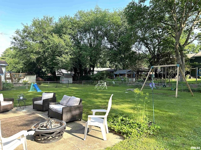 125 Pinehurst Dr, Springfield, IL 62704 - fenced backyard with a playground, a patio, and an outdoor living space with a fire pit