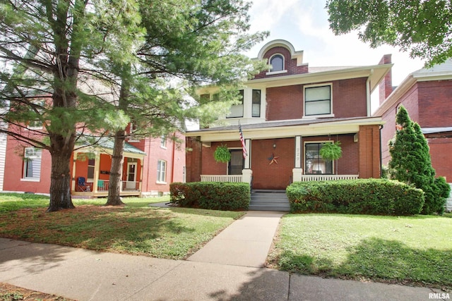 229 S 11th St, Quincy, IL 62301 - view of front of home with covered porch, brick siding, and a front lawn