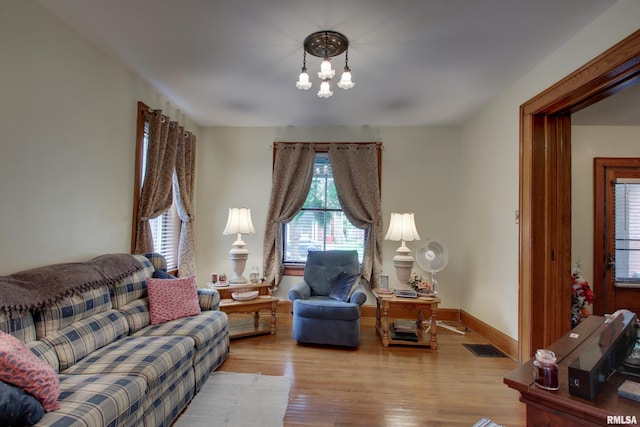 229 S 11th St, Quincy, IL 62301 - living area featuring plenty of natural light, wood finished floors, and a chandelier
