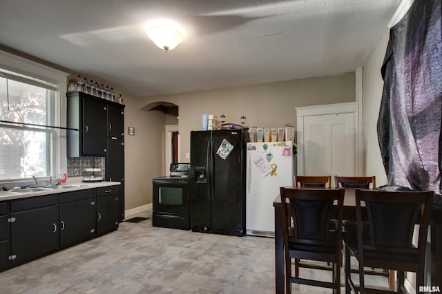 1412 Oak St, Quincy, IL 62301 - kitchen featuring black appliances, arched walkways, light countertops, and dark cabinets