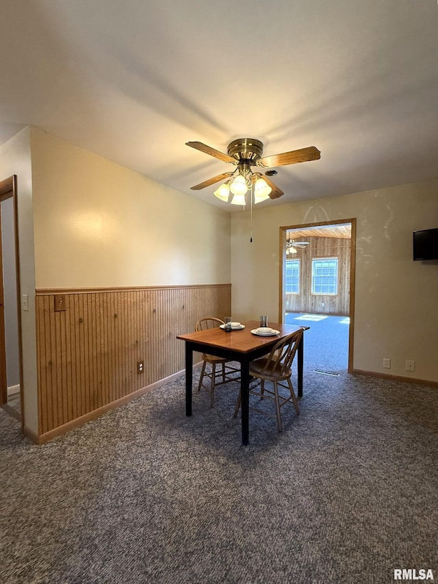 903 N Fearing Ave, Abingdon, IL 61410 - carpeted dining area with a wainscoted wall, ceiling fan, and wooden walls