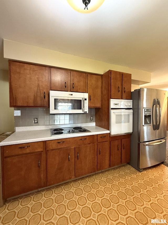 903 N Fearing Ave, Abingdon, IL 61410 - kitchen featuring white appliances, light countertops, tasteful backsplash, brown cabinets, and light flooring