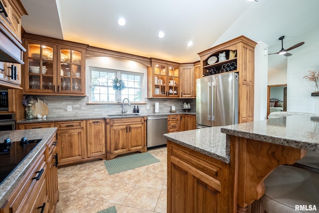 623 Jasper Rd, Centralia, IL 62801 - kitchen with appliances with stainless steel finishes, vaulted ceiling, tasteful backsplash, brown cabinets, and stone countertops