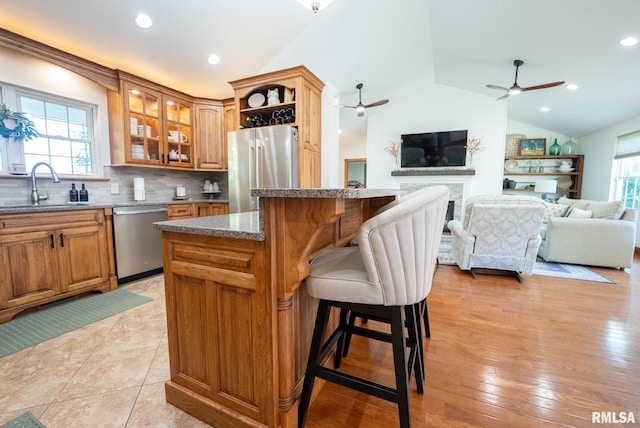 623 Jasper Rd, Centralia, IL 62801 - kitchen featuring stainless steel appliances, vaulted ceiling, a ceiling fan, a kitchen island, and a fireplace