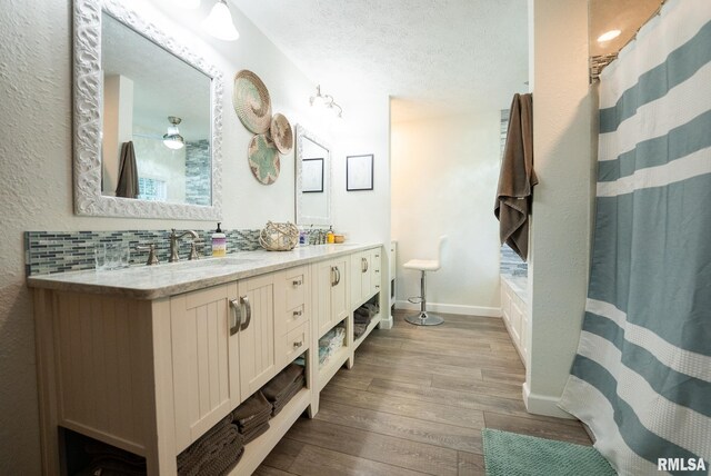 623 Jasper Rd, Centralia, IL 62801 - full bathroom featuring wood finished floors, double vanity, a textured ceiling, and a shower with curtain