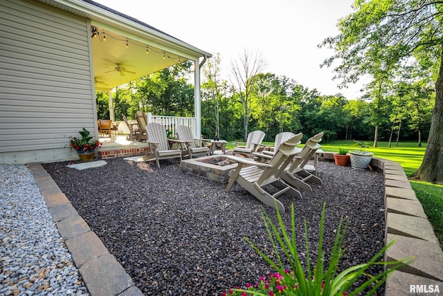 623 Jasper Rd, Centralia, IL 62801 - view of yard featuring a ceiling fan, an outdoor fire pit, a patio, and view of wooded area