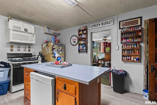 215 N Wilson St, Girard, IL 62640 - kitchen with white appliances, light wood-style floors, light countertops, and a kitchen island