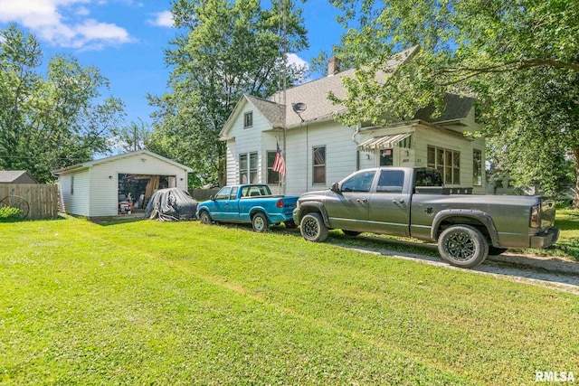 215 N Wilson St, Girard, IL 62640 - view of front facade with an outbuilding, a chimney, a shingled roof, and a garage