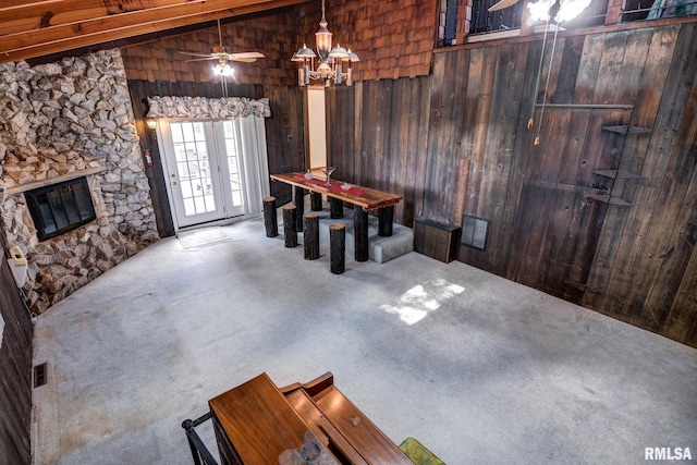 107 E Harrison St, Edinburg, IL 62531 - dining room with carpet floors, wooden walls, lofted ceiling, a stone fireplace, and a ceiling fan