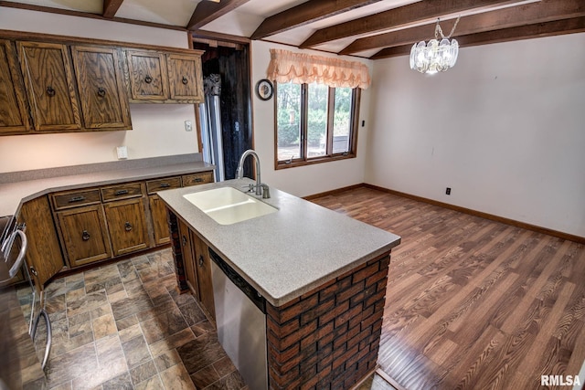107 E Harrison St, Edinburg, IL 62531 - kitchen featuring stainless steel dishwasher, beamed ceiling, hanging light fixtures, a center island with sink, and a chandelier