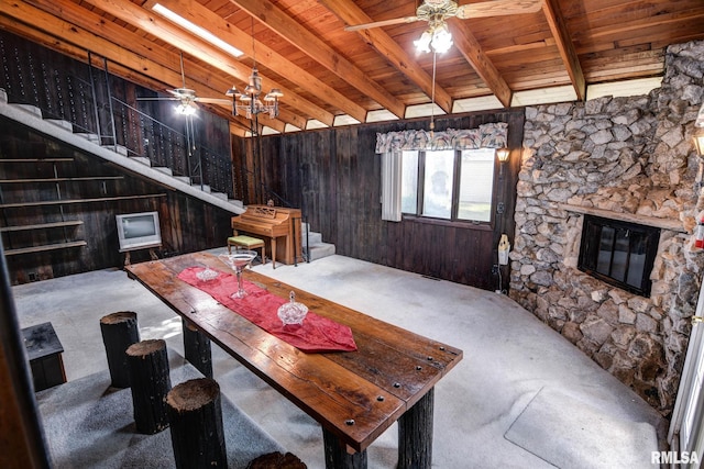 107 E Harrison St, Edinburg, IL 62531 - living area with a ceiling fan, carpet flooring, stairway, a wooden ceiling with exposed beams, and wood walls