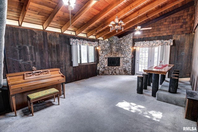 107 E Harrison St, Edinburg, IL 62531 - playroom with wooden ceiling, wood walls, carpet, a stone fireplace, and a ceiling fan