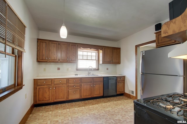1512 Locust St, Quincy, IL 62301 - kitchen with dishwashing machine, freestanding refrigerator, brown cabinets, and light countertops