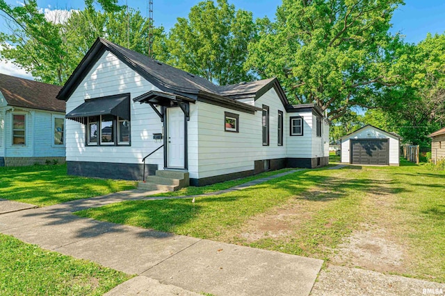 914 Pekin St, Lincoln, IL 62656 - view of front of property featuring driveway, a garage, an outdoor structure, and a front lawn