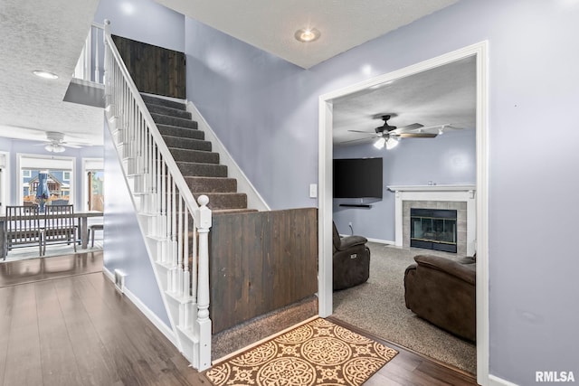 504 Windamere Dr, Sherman, IL 62684 - staircase with a textured ceiling, a ceiling fan, a fireplace, and wood finished floors