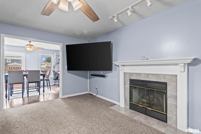 504 Windamere Dr, Sherman, IL 62684 - living area featuring a ceiling fan, a tile fireplace, carpet, and rail lighting