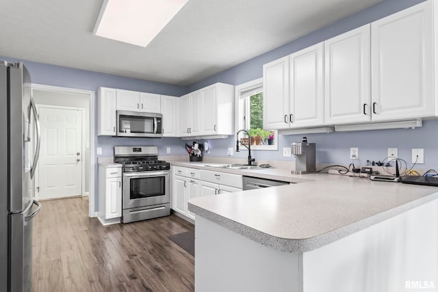 504 Windamere Dr, Sherman, IL 62684 - kitchen featuring appliances with stainless steel finishes, a peninsula, dark wood-style flooring, and light countertops