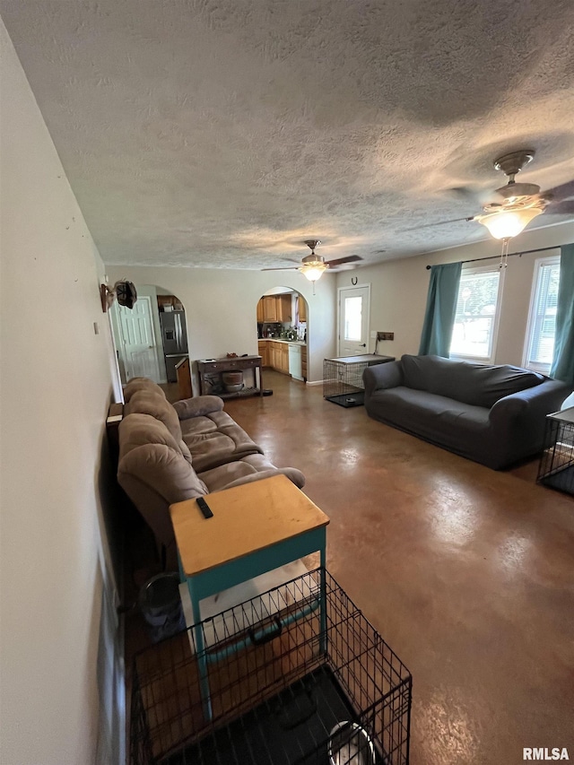 28 Albion St, Lynnville, IL 62650 - living area with ceiling fan, arched walkways, finished concrete flooring, and a textured ceiling