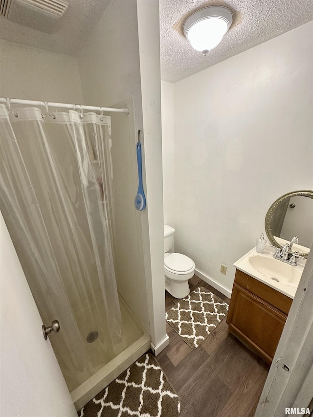 311 Main St, Meredosia, IL 62665 - full bathroom featuring wood finished floors, a textured ceiling, vanity, and a shower stall