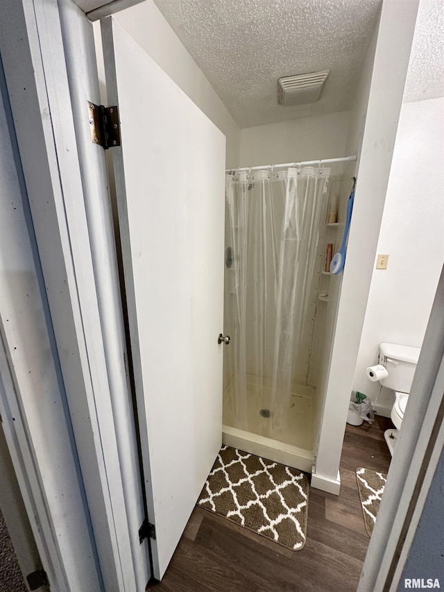 311 Main St, Meredosia, IL 62665 - full bath featuring wood finished floors, a textured ceiling, and a shower with shower curtain