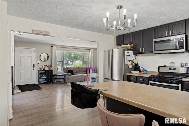749 E Andrew Rd, Springfield, IL 62707 - kitchen featuring appliances with stainless steel finishes, light wood-type flooring, a chandelier, light countertops, and a textured ceiling