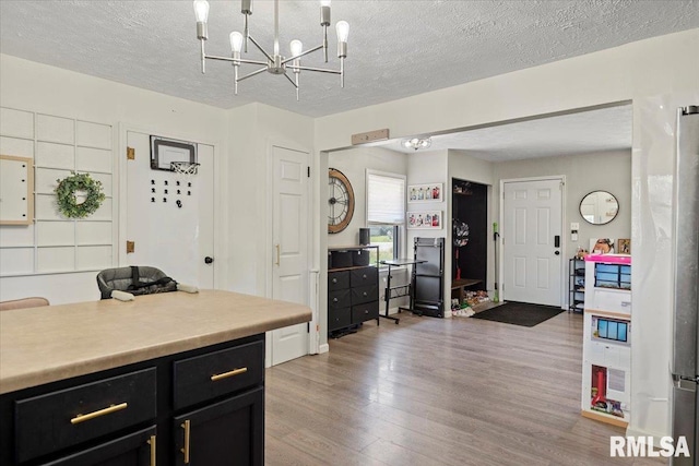 749 E Andrew Rd, Springfield, IL 62707 - kitchen with light wood finished floors, light countertops, a chandelier, dark cabinets, and a textured ceiling