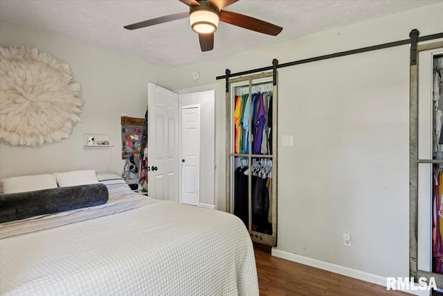 749 E Andrew Rd, Springfield, IL 62707 - bedroom with a barn door, wood finished floors, a textured ceiling, and ceiling fan
