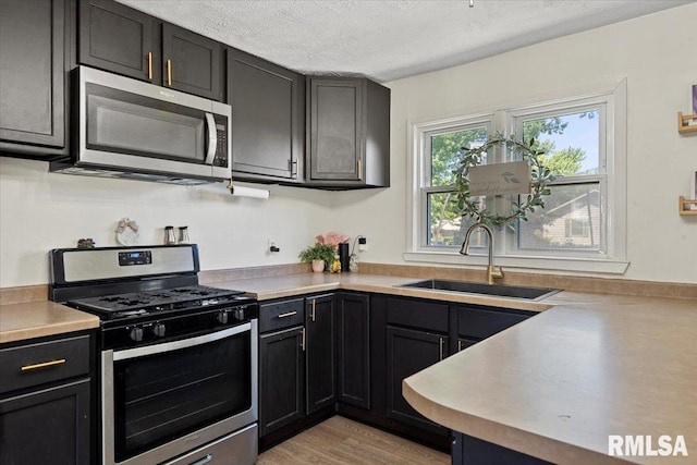 749 E Andrew Rd, Springfield, IL 62707 - kitchen featuring appliances with stainless steel finishes, a textured ceiling, light wood-style flooring, and light countertops