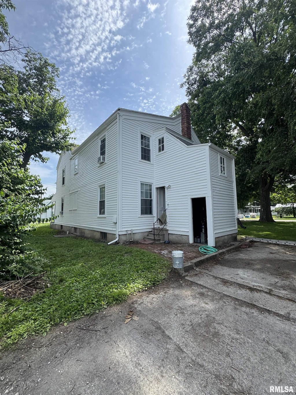 203 E Jefferson St, Rushville, IL 62681 - view of front of house with entry steps, a chimney, and a front yard