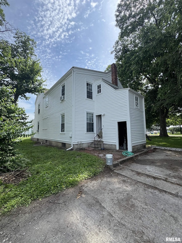 203 E Jefferson St, Rushville, IL 62681 - view of front of house with entry steps, a chimney, and a front yard