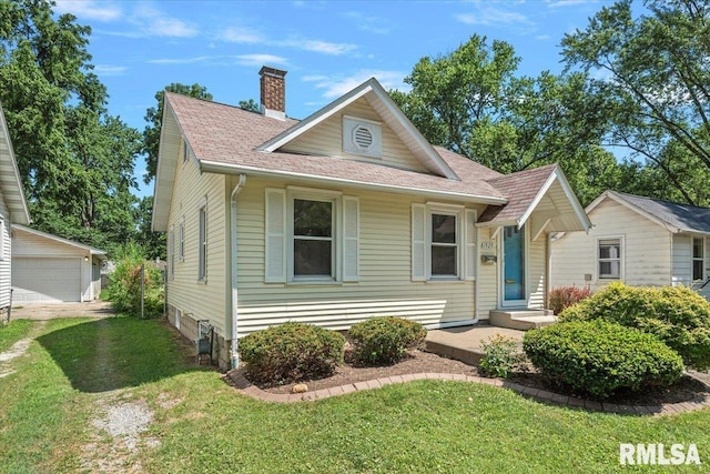 1529 W Reed Ave, Springfield, IL 62704 - view of front of home with a chimney, a front yard, a shingled roof, an outdoor structure, and a garage