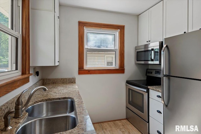 1529 W Reed Ave, Springfield, IL 62704 - kitchen featuring stainless steel appliances, white cabinetry, light stone counters, and light wood-type flooring
