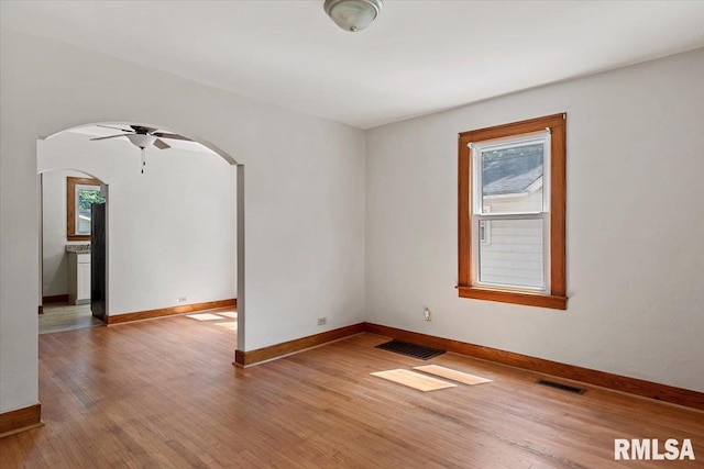 1529 W Reed Ave, Springfield, IL 62704 - spare room with arched walkways, healthy amount of natural light, a ceiling fan, and wood finished floors
