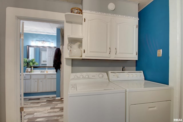 624 Monroe St, Quincy, IL 62301 - laundry area with washer and dryer, light wood finished floors, cabinet space, and ornamental molding