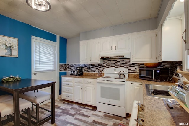 624 Monroe St, Quincy, IL 62301 - kitchen featuring white electric range oven, stainless steel microwave, backsplash, light wood-style flooring, and white cabinets