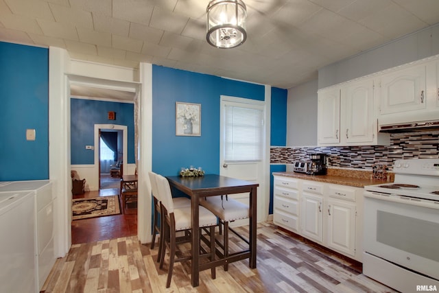 624 Monroe St, Quincy, IL 62301 - kitchen featuring white electric range, washing machine and clothes dryer, light wood finished floors, white cabinetry, and backsplash