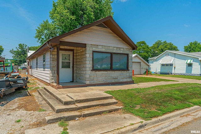 1231 Pulaski St, Lincoln, IL 62656 - view of front of home with stone siding, a detached garage, and a front yard
