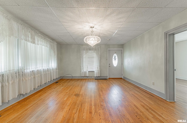 1231 Pulaski St, Lincoln, IL 62656 - spare room featuring wood finished floors, a chandelier, and a drop ceiling