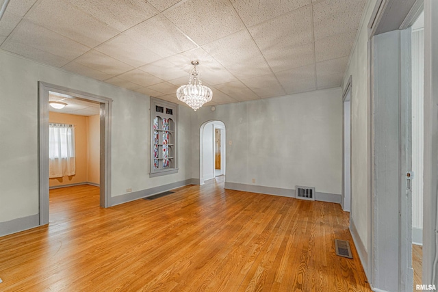 1231 Pulaski St, Lincoln, IL 62656 - unfurnished room with arched walkways, light wood-type flooring, and a chandelier