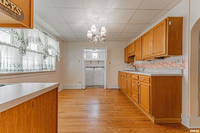 1231 Pulaski St, Lincoln, IL 62656 - kitchen with independent washer and dryer, a chandelier, light countertops, light wood-style flooring, and a paneled ceiling