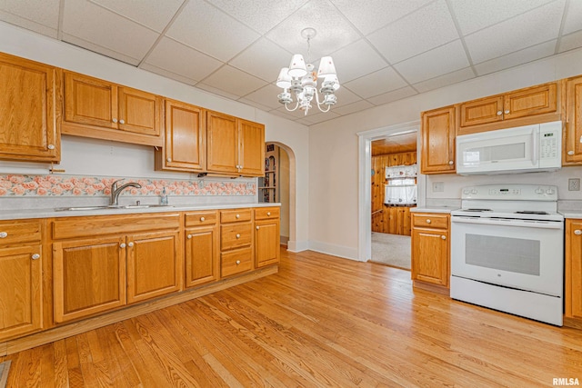 1231 Pulaski St, Lincoln, IL 62656 - kitchen featuring white appliances, arched walkways, a chandelier, light countertops, and light wood-type flooring