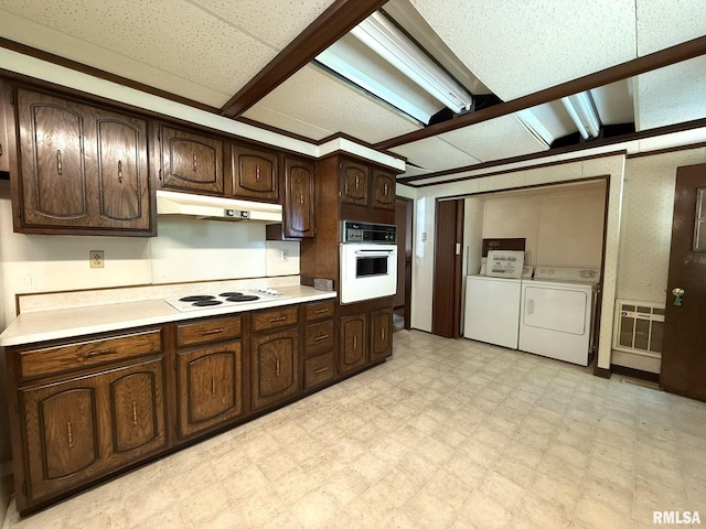 573 Matthews Ct, Oneida, IL 61467 - kitchen with white appliances, washer and dryer, under cabinet range hood, light flooring, and light countertops