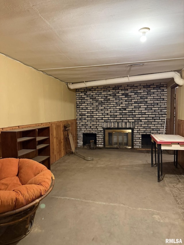 573 Matthews Ct, Oneida, IL 61467 - living room featuring a fireplace, unfinished concrete flooring, wainscoting, and wooden walls