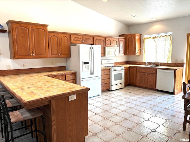 4317 Harvard Dr, Springfield, IL 62712 - kitchen with white appliances, a peninsula, brown cabinetry, lofted ceiling, and recessed lighting
