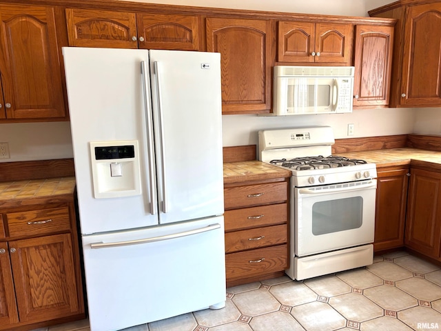4317 Harvard Dr, Springfield, IL 62712 - kitchen featuring white appliances, tile counters, and brown cabinetry