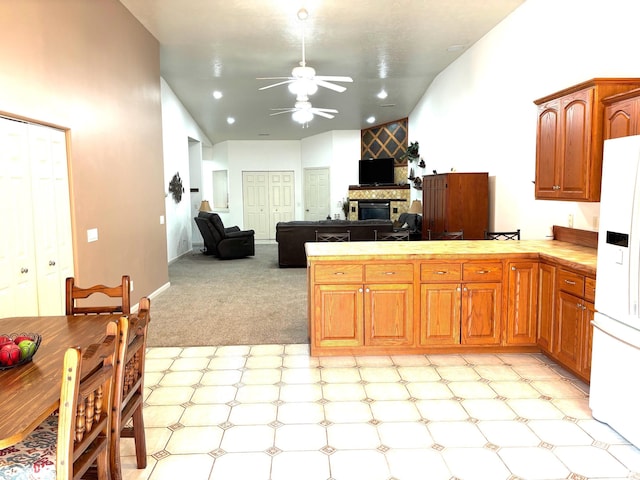 4317 Harvard Dr, Springfield, IL 62712 - kitchen with a ceiling fan, white fridge with ice dispenser, a peninsula, a large fireplace, and vaulted ceiling