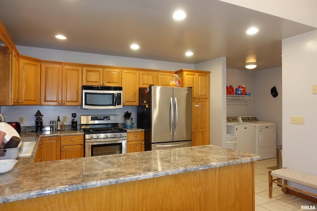 1156 Russell Ave, Galesburg, IL 61401 - kitchen featuring stainless steel appliances, separate washer and dryer, a peninsula, light tile patterned floors, and recessed lighting